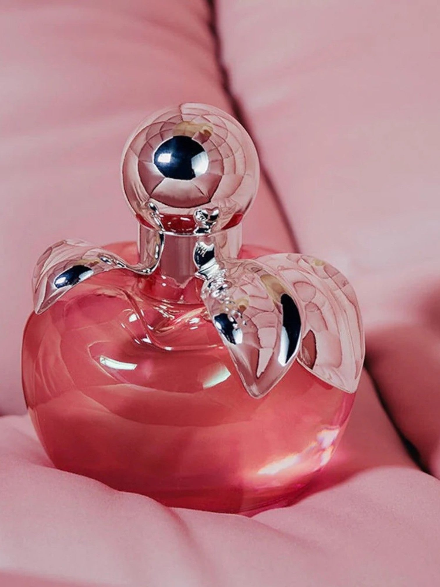 Pink perfume bottle with silver cap on a pink background. Nina, Monza Outlet, Monza Fashion, Shein Outlet