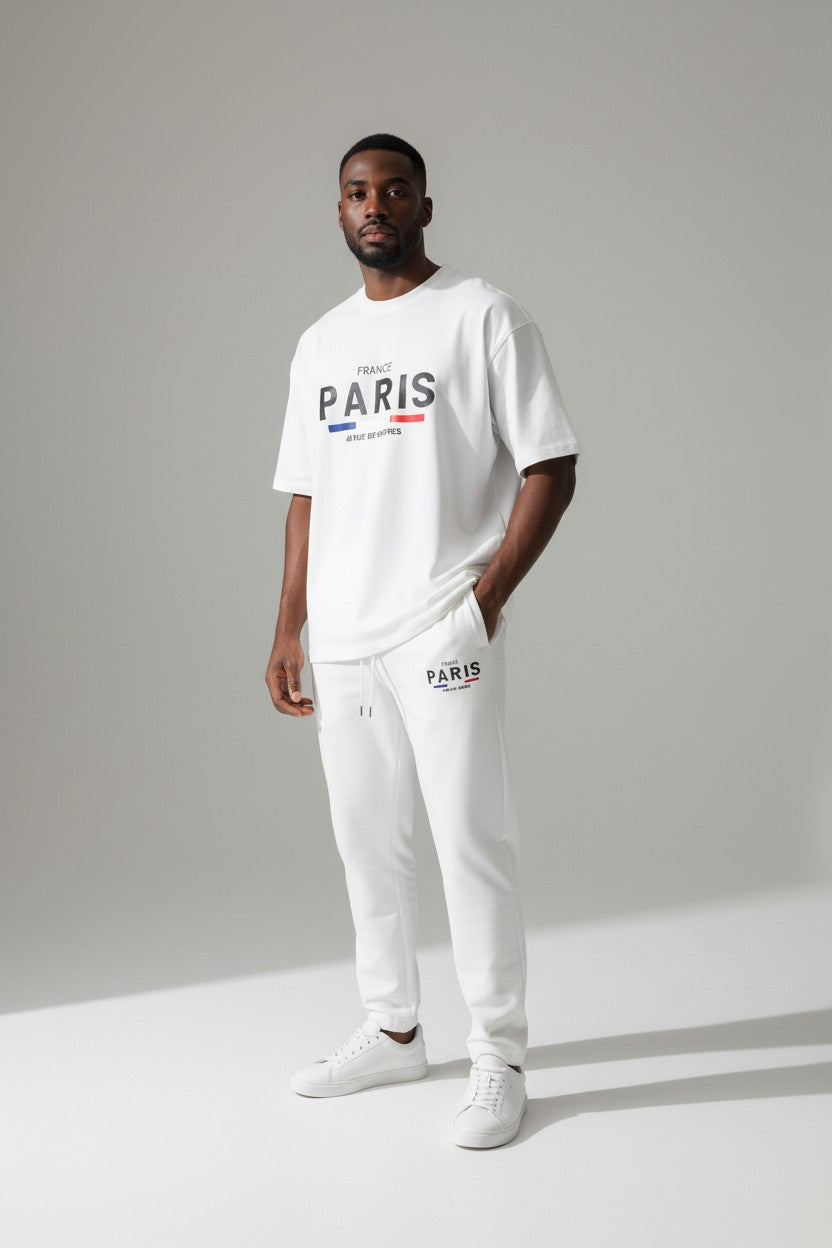 Man wearing a white Paris t-shirt and pants on a gray background. Antler, Monza Outlet, Monza Fashion, Shein Outlet