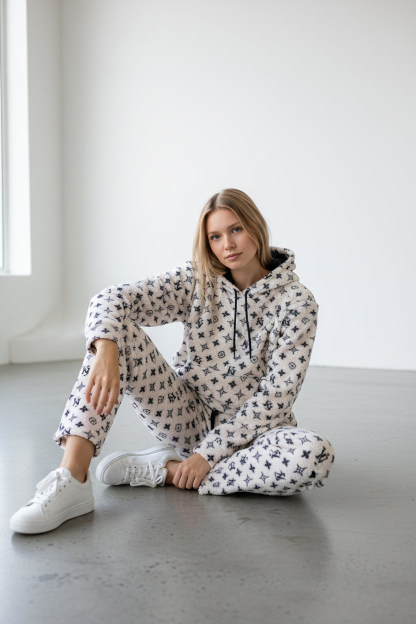 Woman wearing a patterned onesie sitting on a concrete floor with a white background. Antler, Monza Outlet, Monza Fashion, Shein Outlet