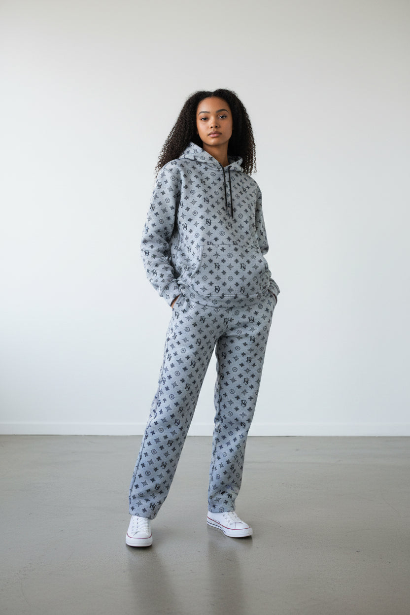 Person wearing a gray patterned hoodie and pants set against a plain background. Antler, Monza Outlet, Monza Fashion, Shein Outlet