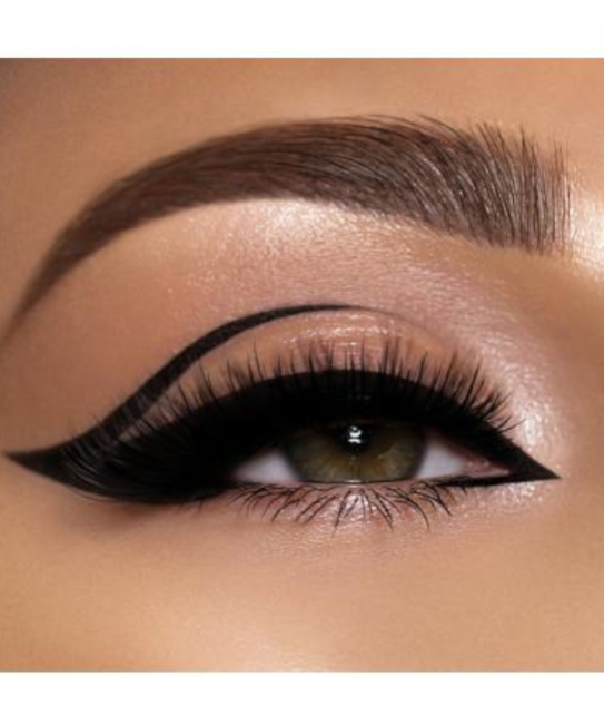 Close-up of an eye with a cat-eye makeup look on a beige background. Pat McGrath Labs Monza Outlet