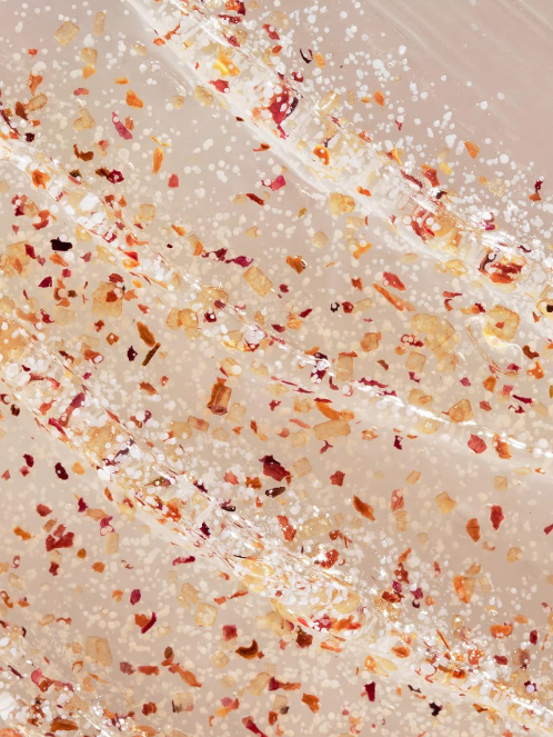 Close-up of a textured surface with specks of red, orange, and yellow on a white background. Summer Fridays, Monza Outlet, Monza Fashion, Shein Outlet
