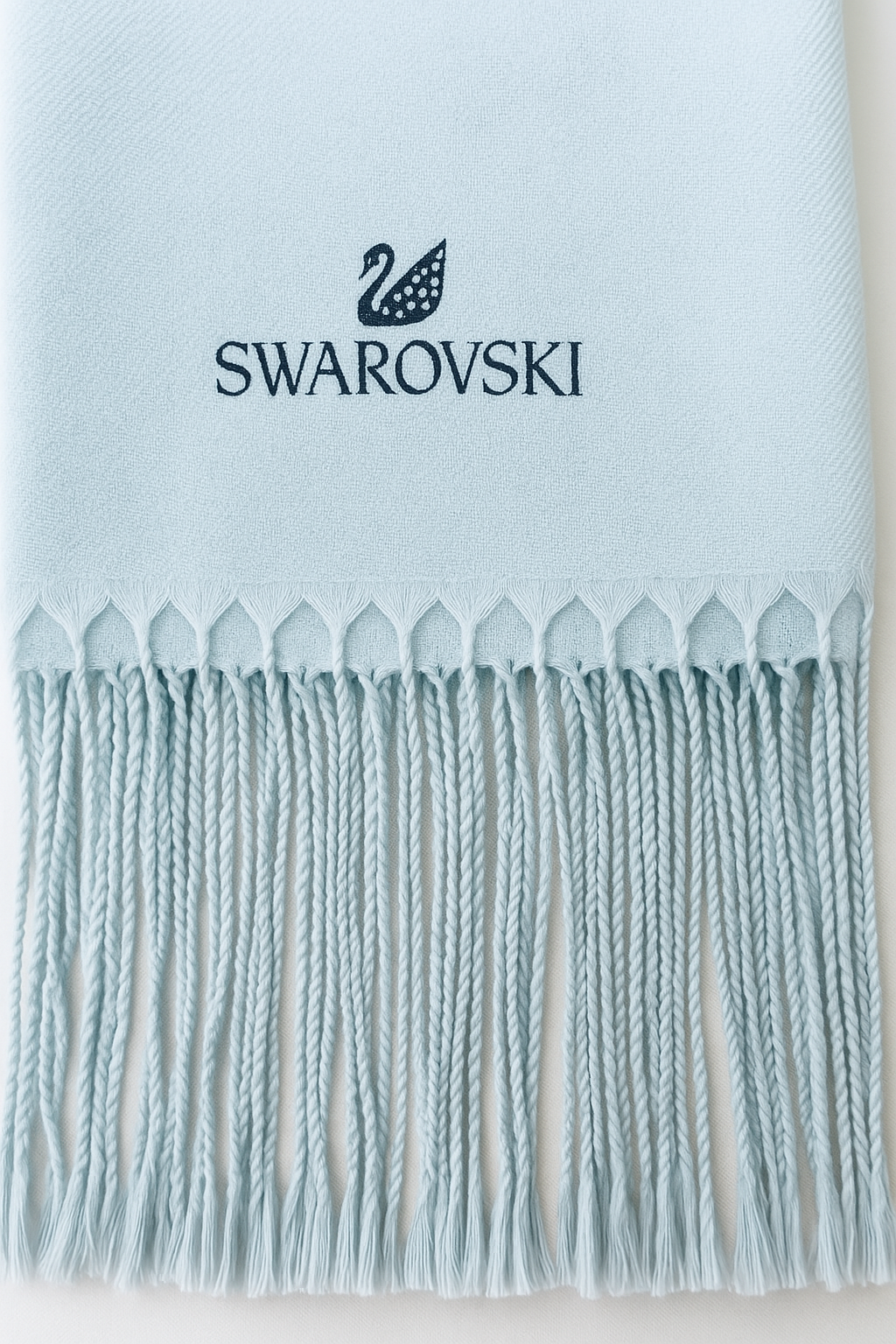 Light blue scarf with Swarovski logo on a light background. Swarovski Monza Outlet