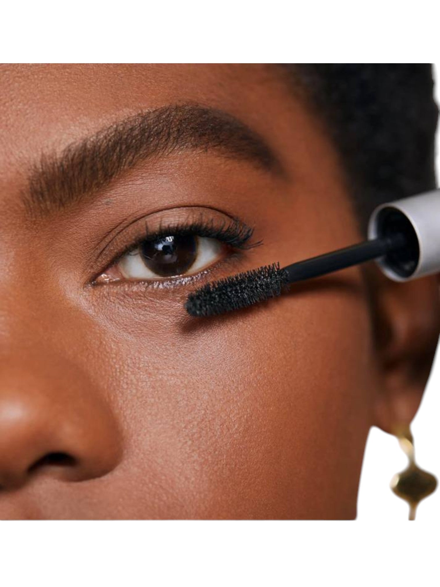 Person applying mascara to their eyelashes with a close-up focus on the eye area. monza outlet, Shein outlet, monza fashion