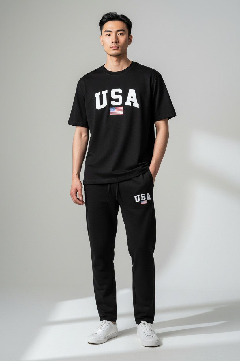 Person wearing a black USA t-shirt and pants on a gray background. Antler, Monza Outlet, Monza Fashion, Shein Outlet