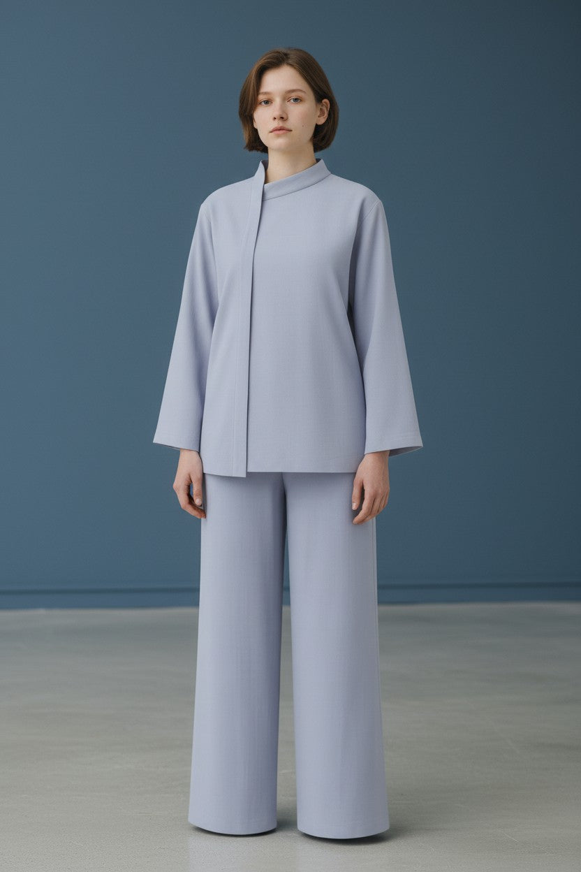 Person wearing a light gray outfit against a blue background. Antler, Monza Outlet, Monza Fashion, Shein Outlet