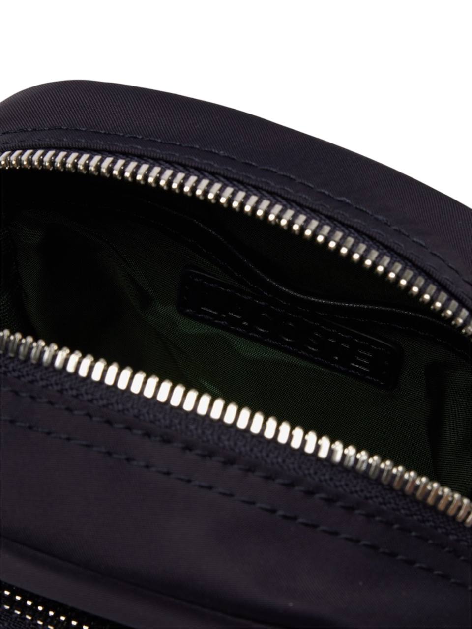 Close-up of a navy blue bag with a zipper, featuring the brand name Ferragamo. Monza Outlet