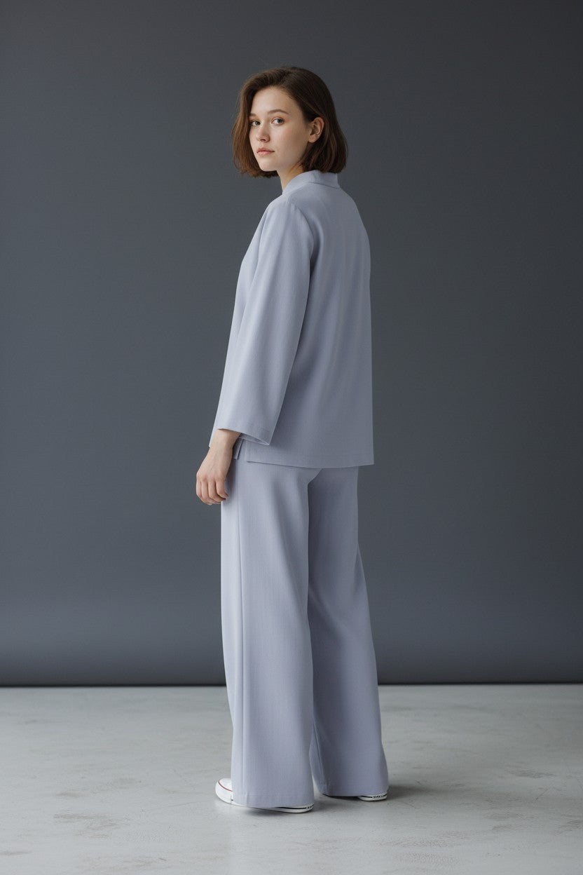 Woman wearing a light gray outfit against a dark gray background. Antler, Monza Outlet, Monza Fashion, Shein Outlet