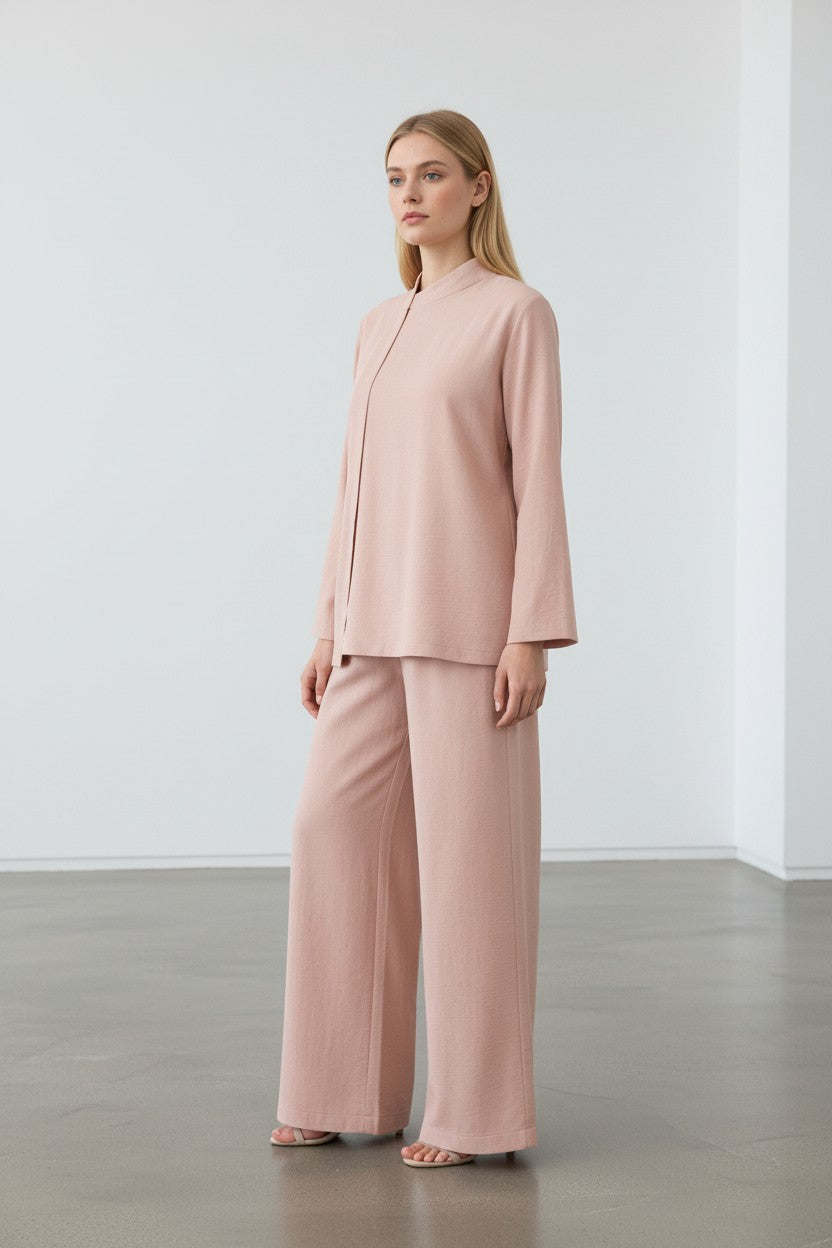 Woman wearing a pink suit standing against a white wall. Antler, Monza Outlet, Monza Fashion, Shein Outlet