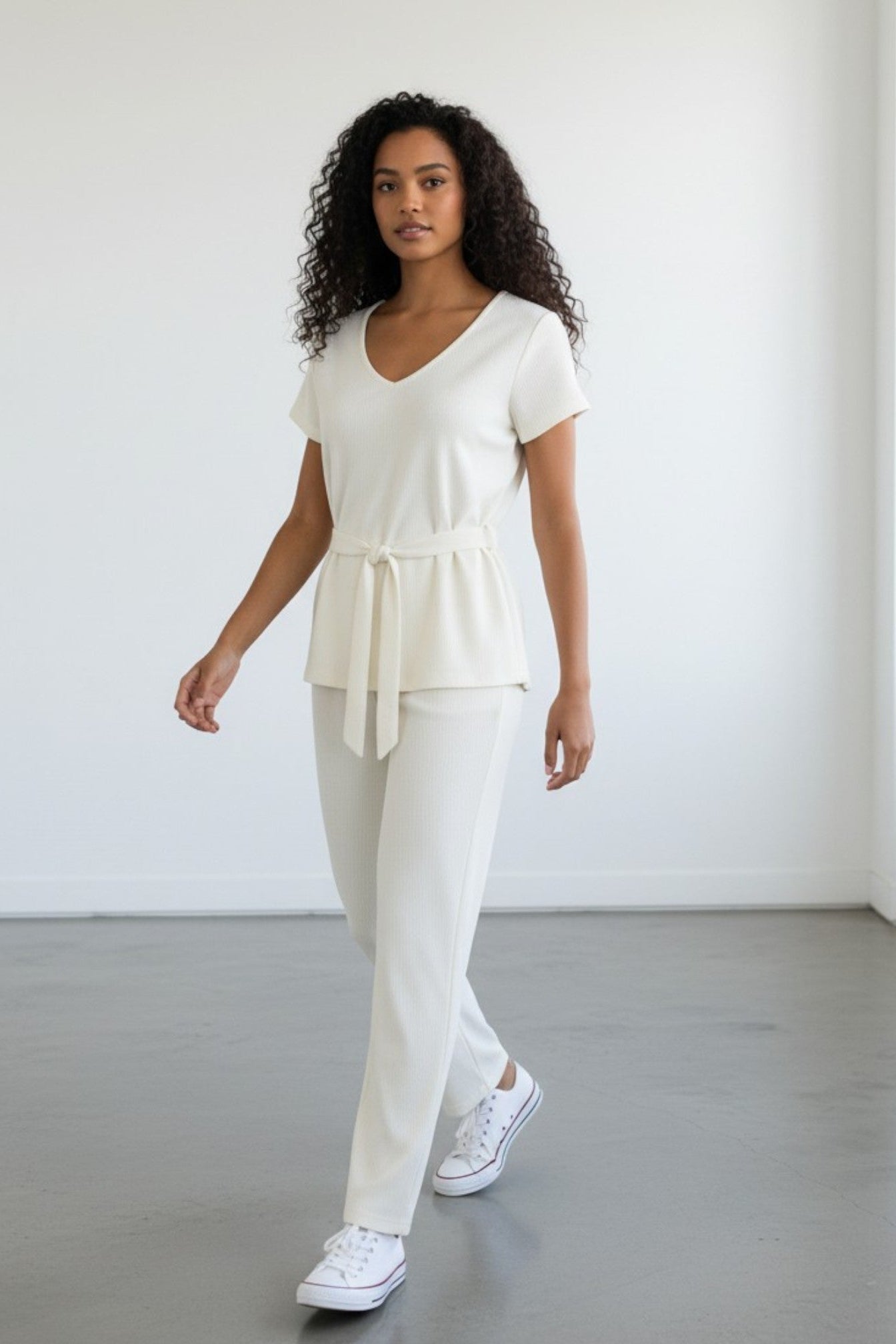 Woman wearing a white outfit with a plain background