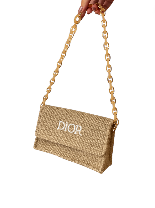 Beige handbag with Dior logo held by a hand on a white background. Monza Outlet