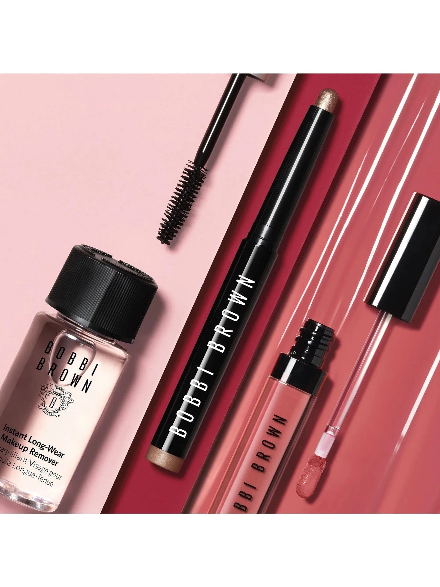 Bobbi Brown makeup products including mascara, eyeliner, and primer on a pink background. Bobbi Brown, Monza Outlet, Monza Fashion, Shein Outlet