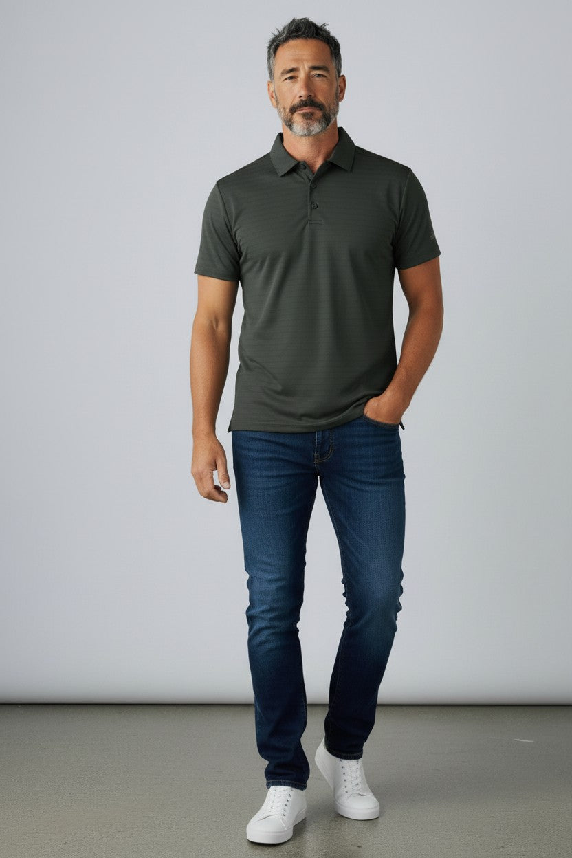 Man wearing a green polo shirt and blue jeans standing against a plain background. Adidas, Monza Outlet, Monza Fashion, Shein Outlet