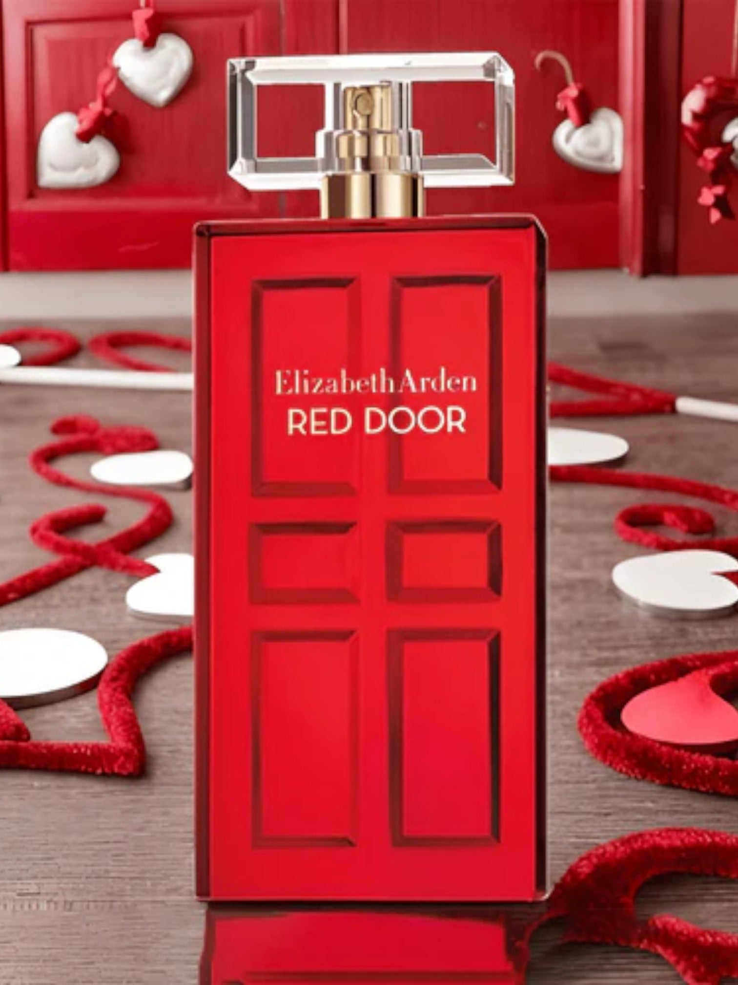 Red Door perfume bottle by Elizabeth Arden on a decorative background with hearts. Elizabeth Arden, Monza Outlet, Monza Fashion, Shein Outlet