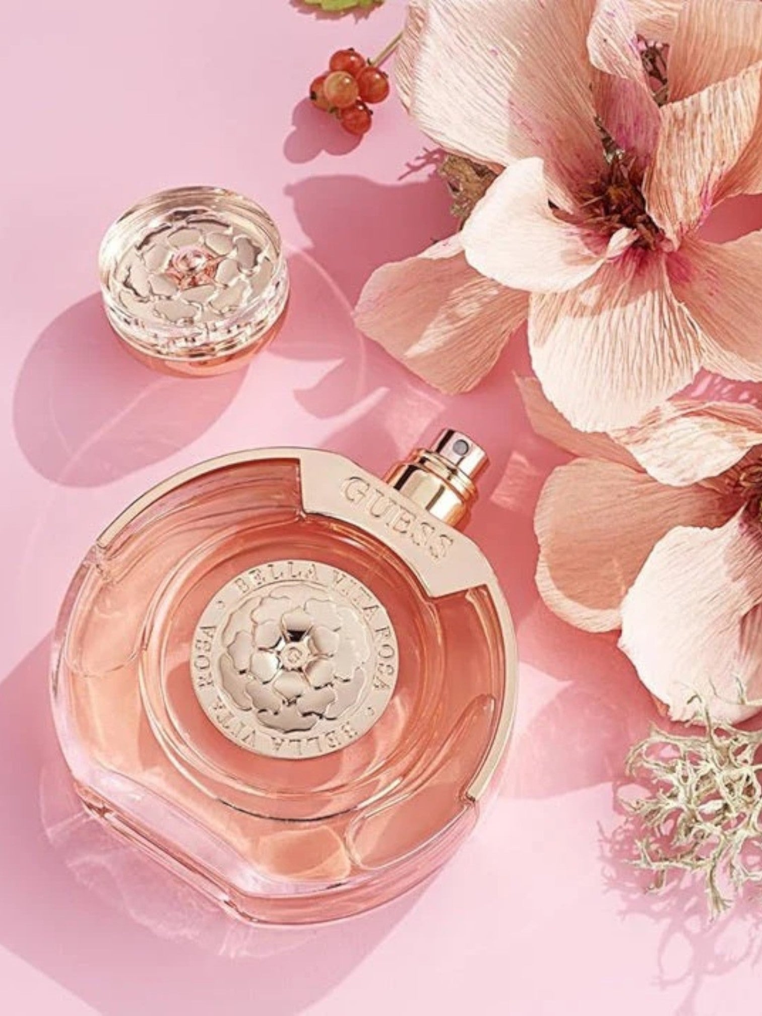 Guess perfume bottle with floral elements on a pink background monza outlet, Shein outlet, monza fashion
