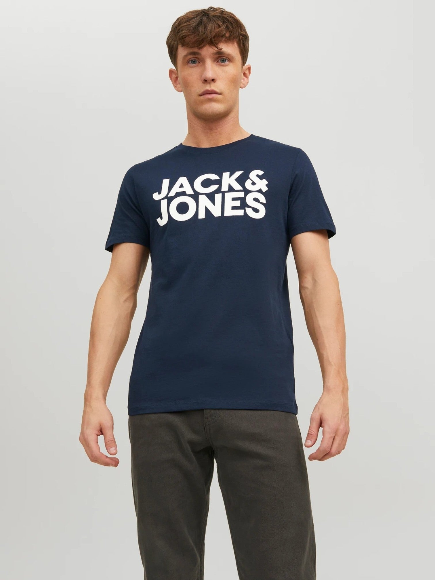 Man wearing a navy 'Jack & Jones' t-shirt on a light gray background. Jack & Jones, Monza Outlet, Monza Fashion, Shein Outlet
