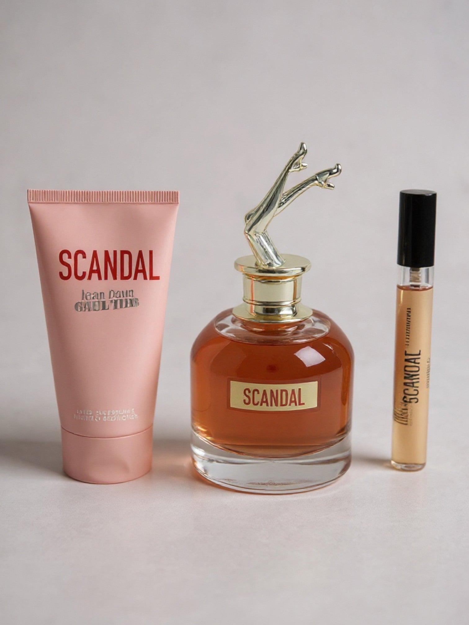 Scandal perfume set with a tube, bottle, and smaller container on a light background. Jean Paul Gaultier, Monza Outlet, Monza Fashion, Shein Outlet