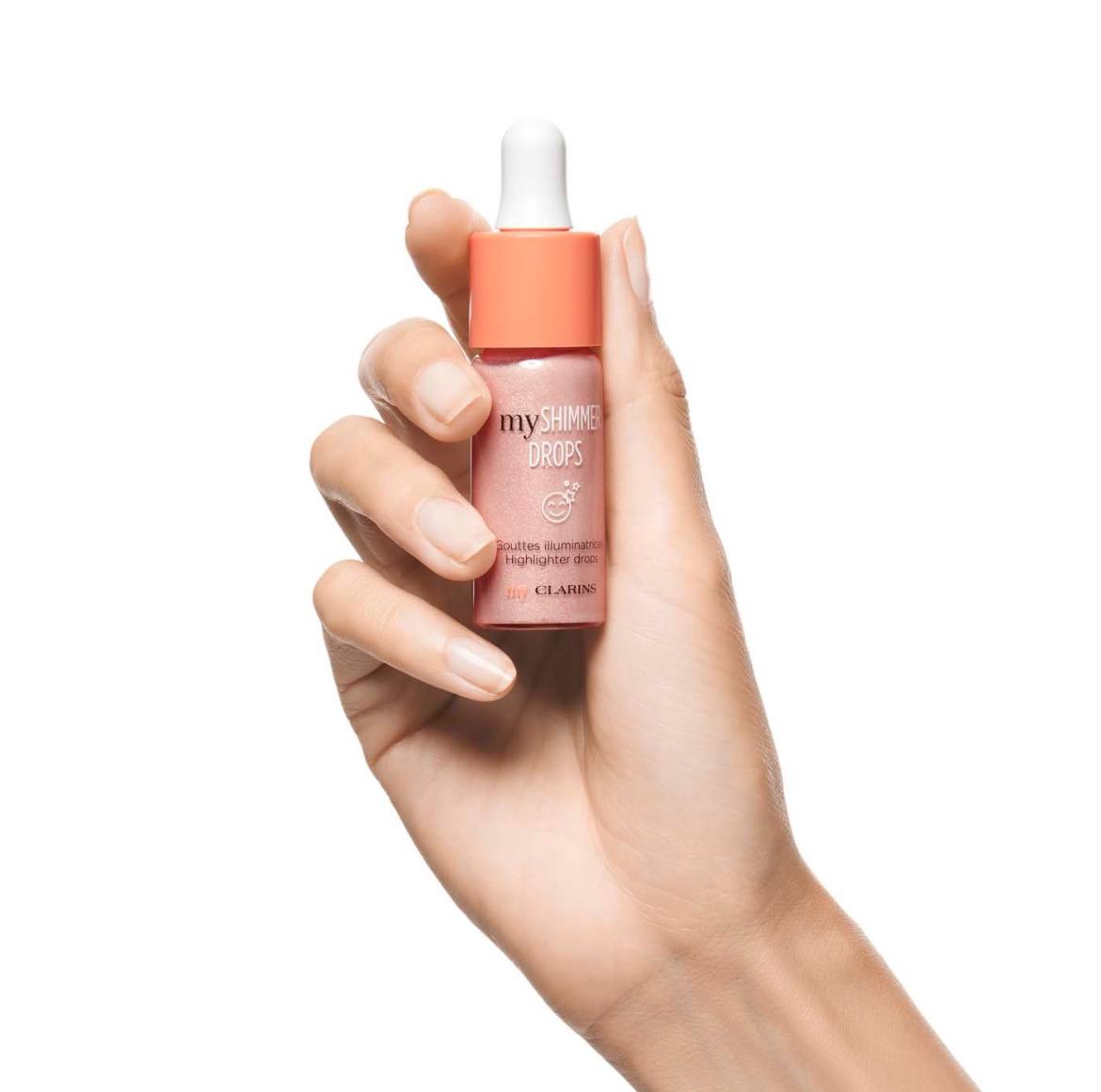 Hand holding a bottle of Clarins product on a white background monza outlet, Shein outlet, monza fashion