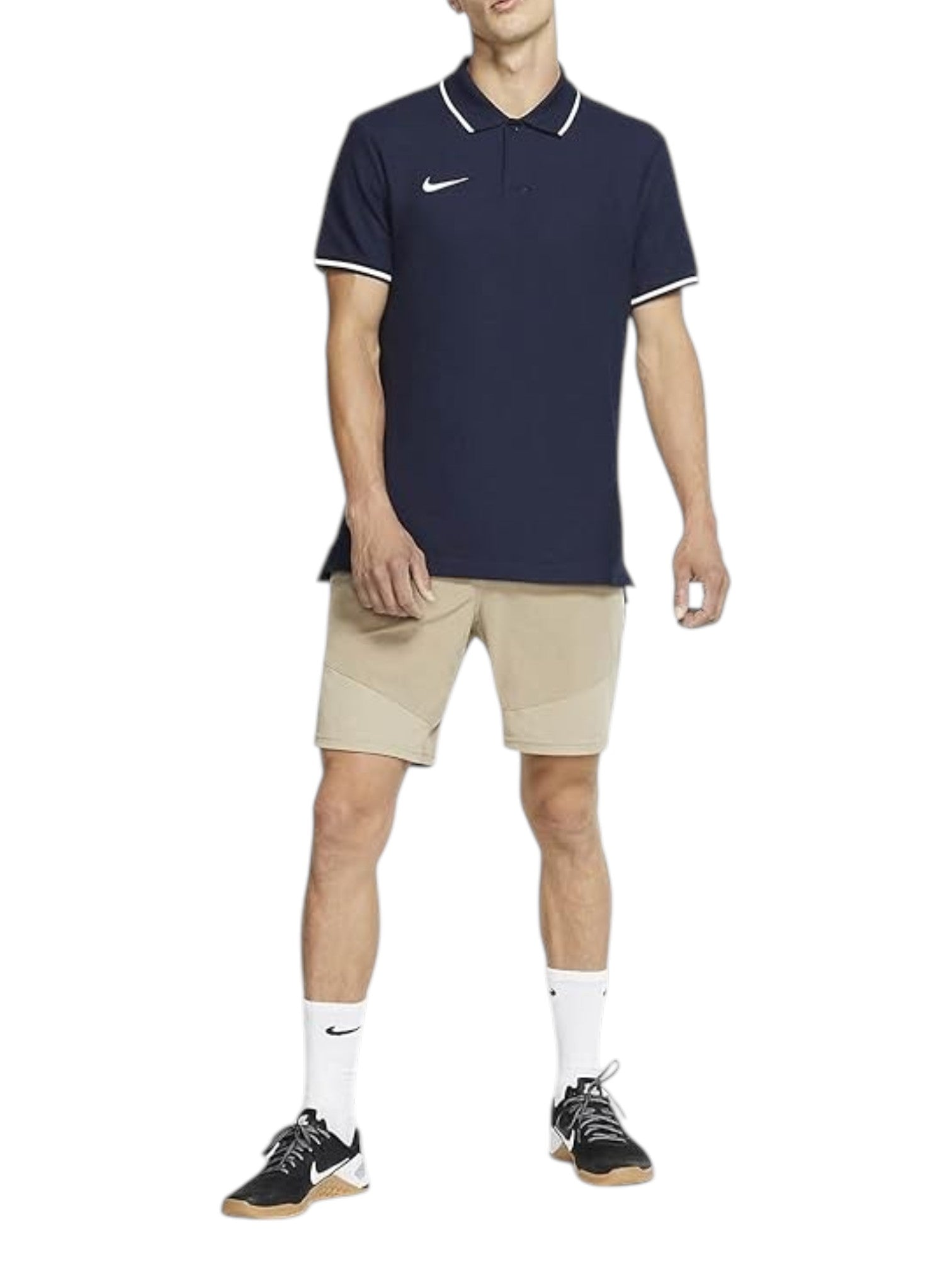Person wearing a navy Nike polo shirt and beige shorts on a white background. Nike, Monza Outlet, Monza Fashion, Shein Outlet