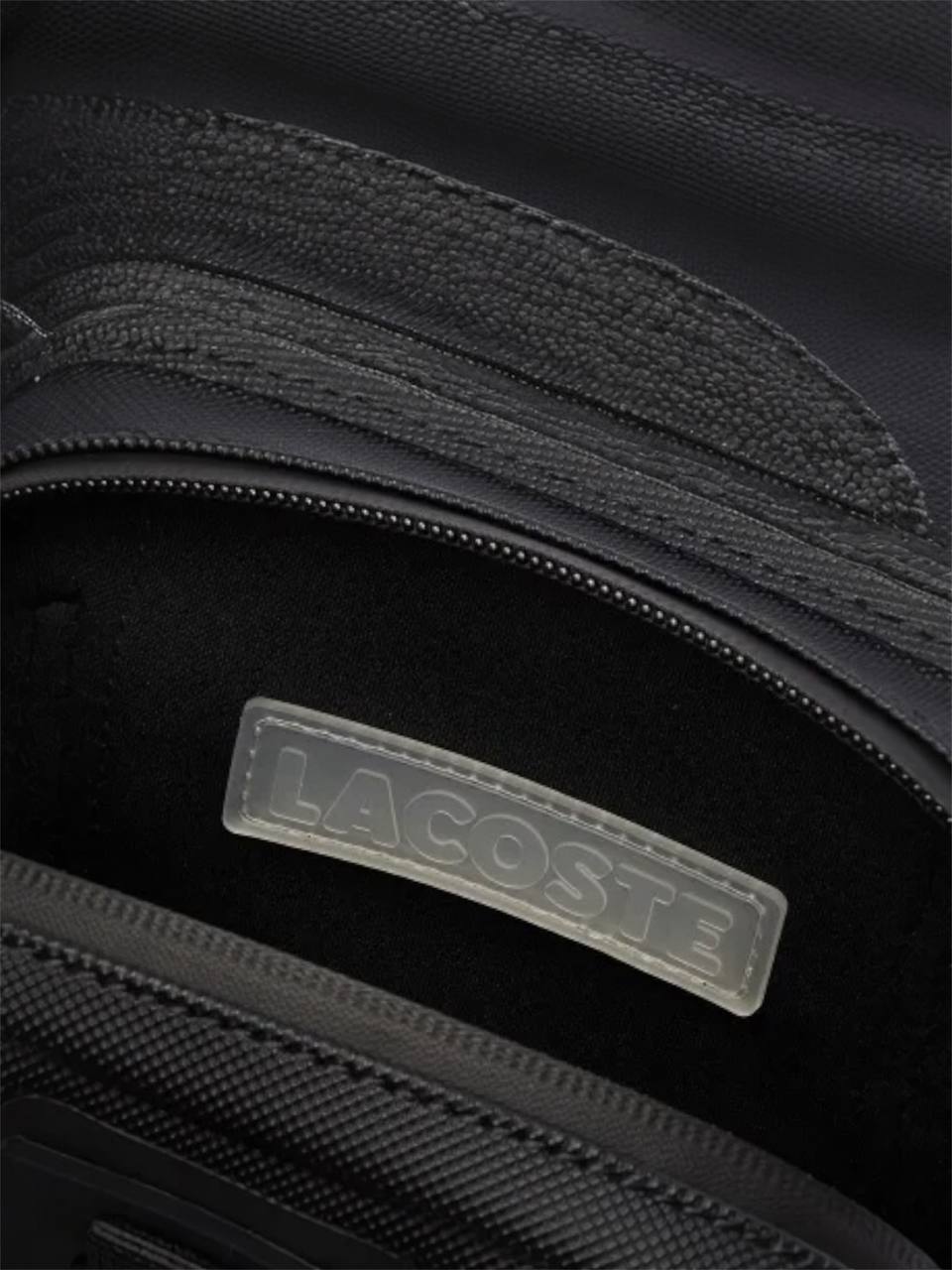 Close-up of a black bag with a Lacoste logo on a dark background Lacoste Monza Outlet