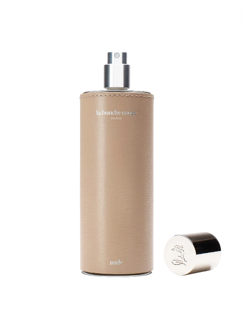 Beige spray bottle with silver cap on a white background