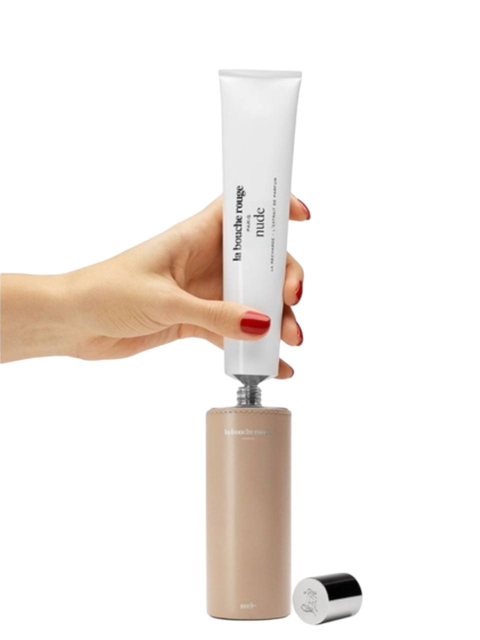 Hand holding a cosmetic tube with a beige base on a white background