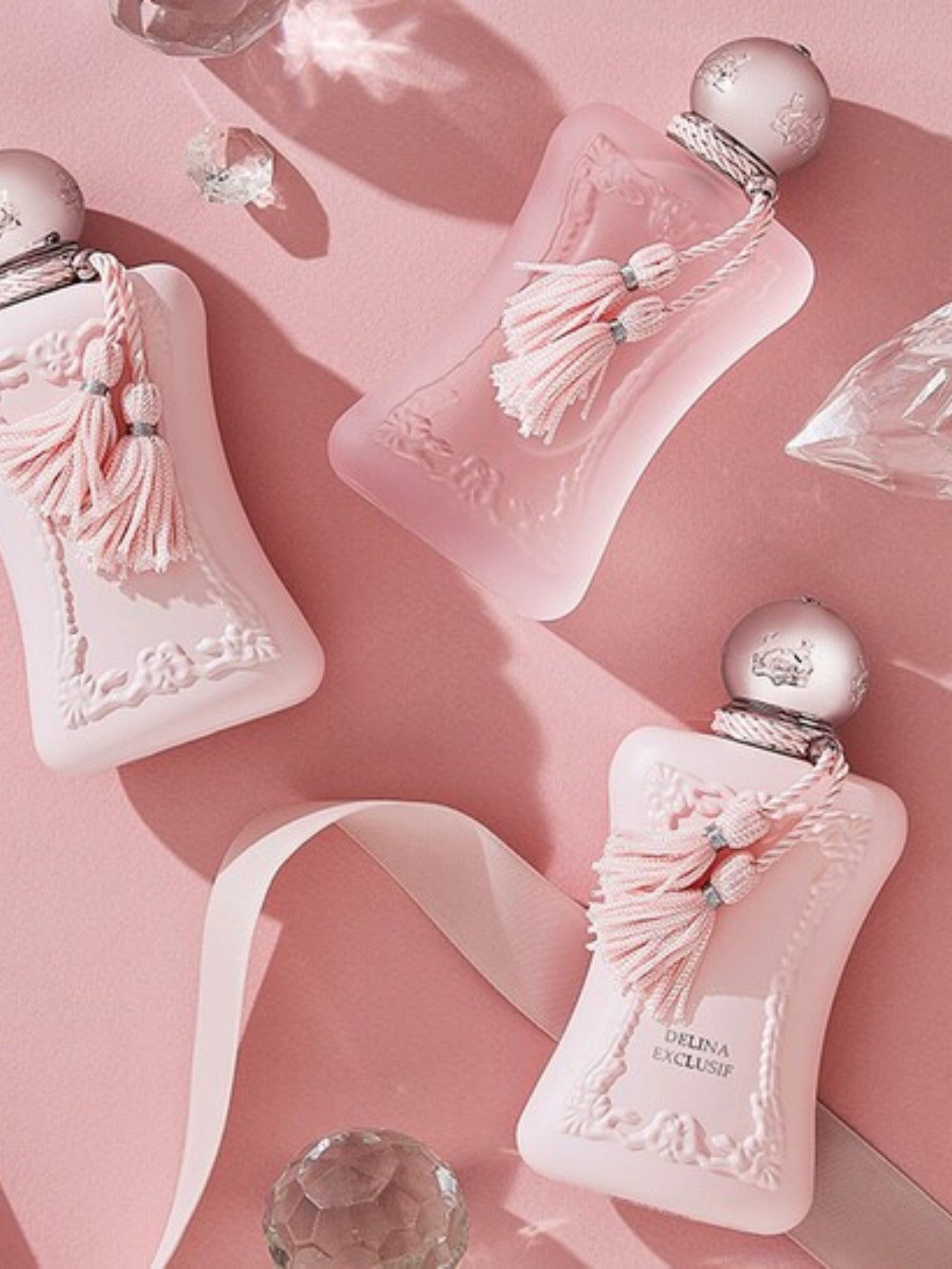 Pink perfume bottles with decorative elements on a pink background. Parfums De Marly, Monza Outlet, Monza Fashion, Shein Outlet