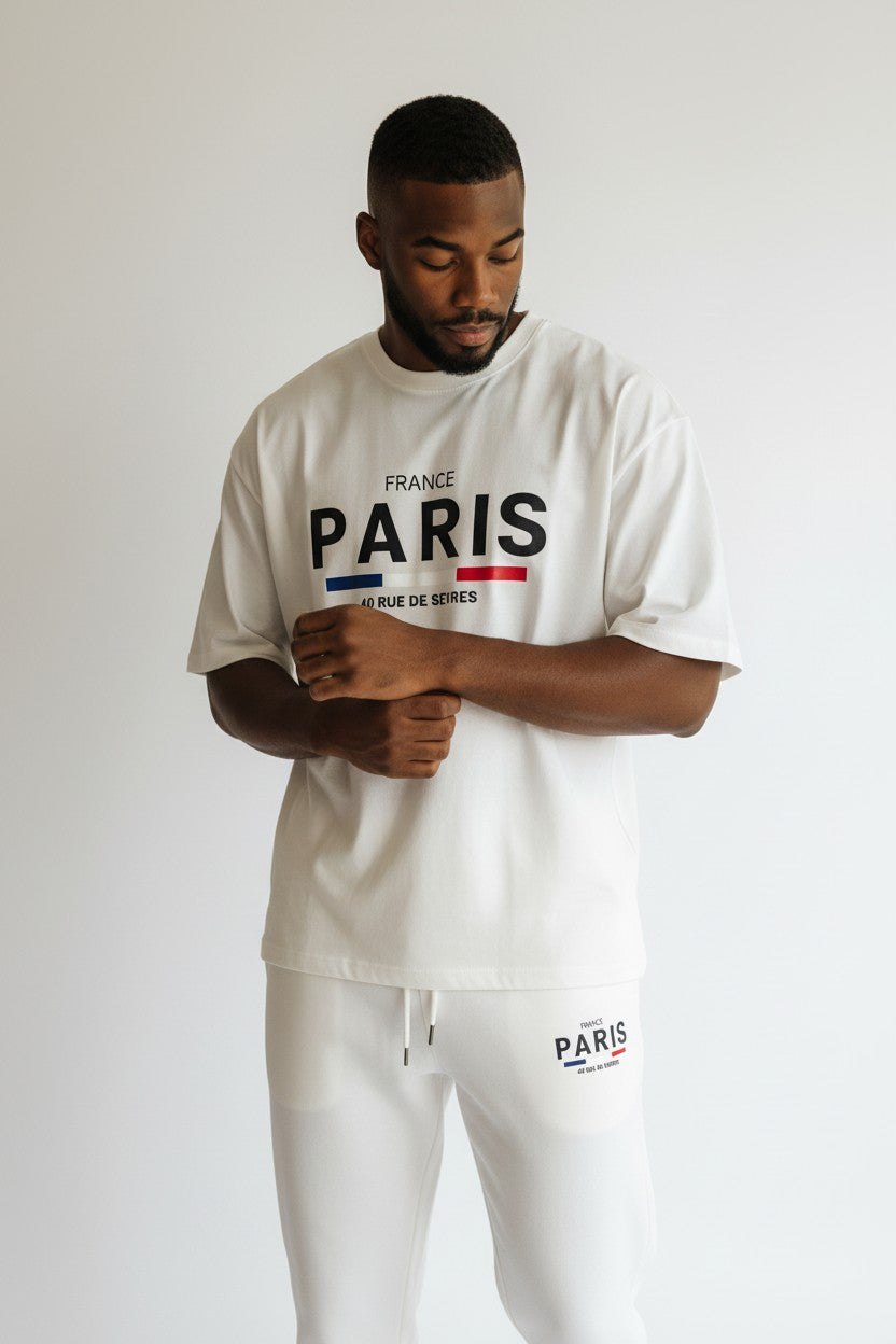 Man wearing a white Paris t-shirt and pants with brand logo on a plain background. Antler, Monza Outlet, Monza Fashion, Shein Outlet