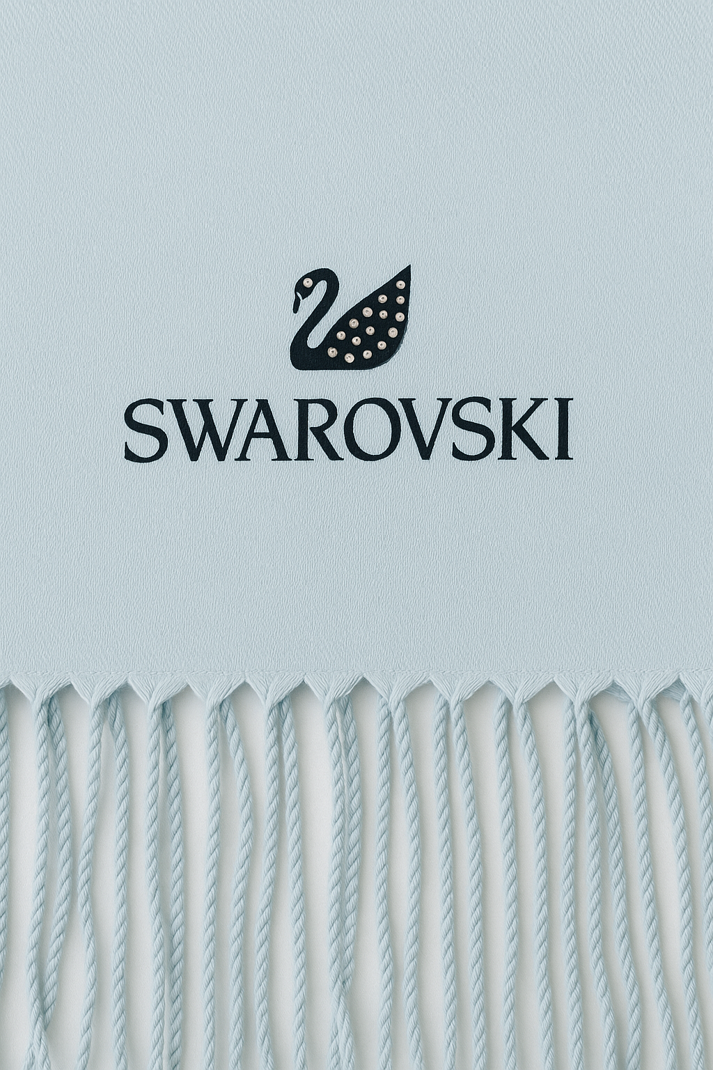 Swarovski logo on a light blue background with decorative elements at the bottom. Monza Outlet