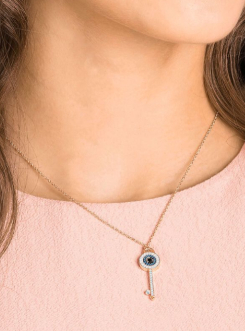 Necklace with a key-shaped pendant featuring an eye design on a person wearing a pink top. monza outlet, Shein outlet, monza fashion