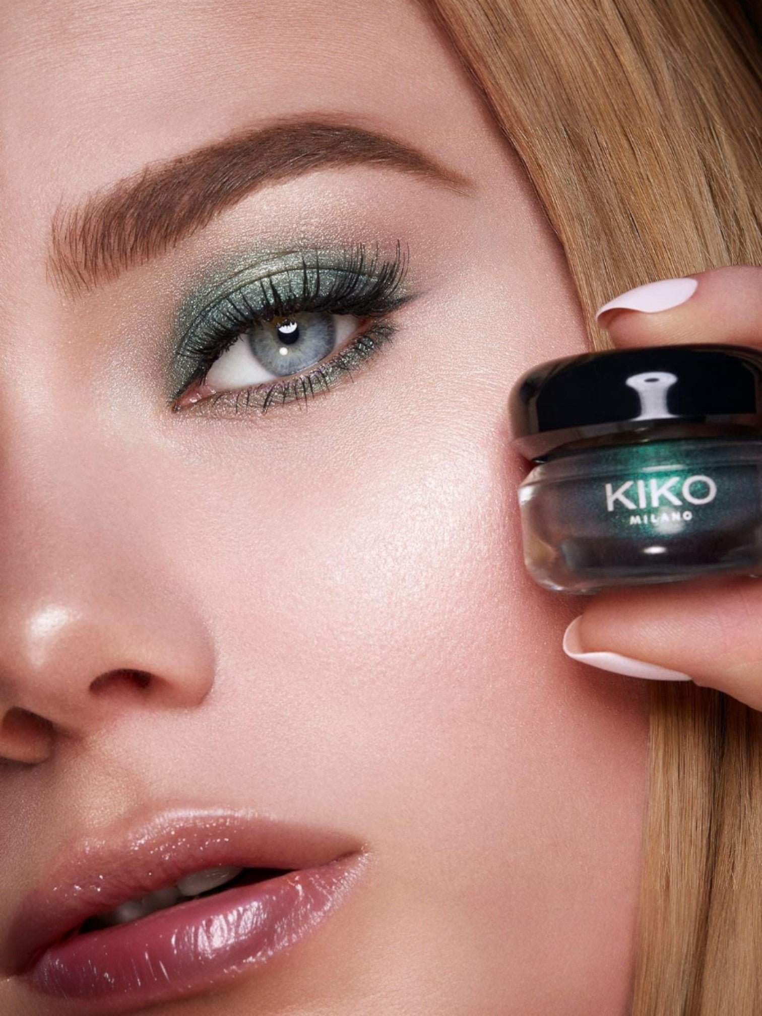 Close-up of a woman applying green eyeshadow with a Kiko Milano jar. Kiko Milano, Monza Outlet, Monza Fashion, Shein Outlet