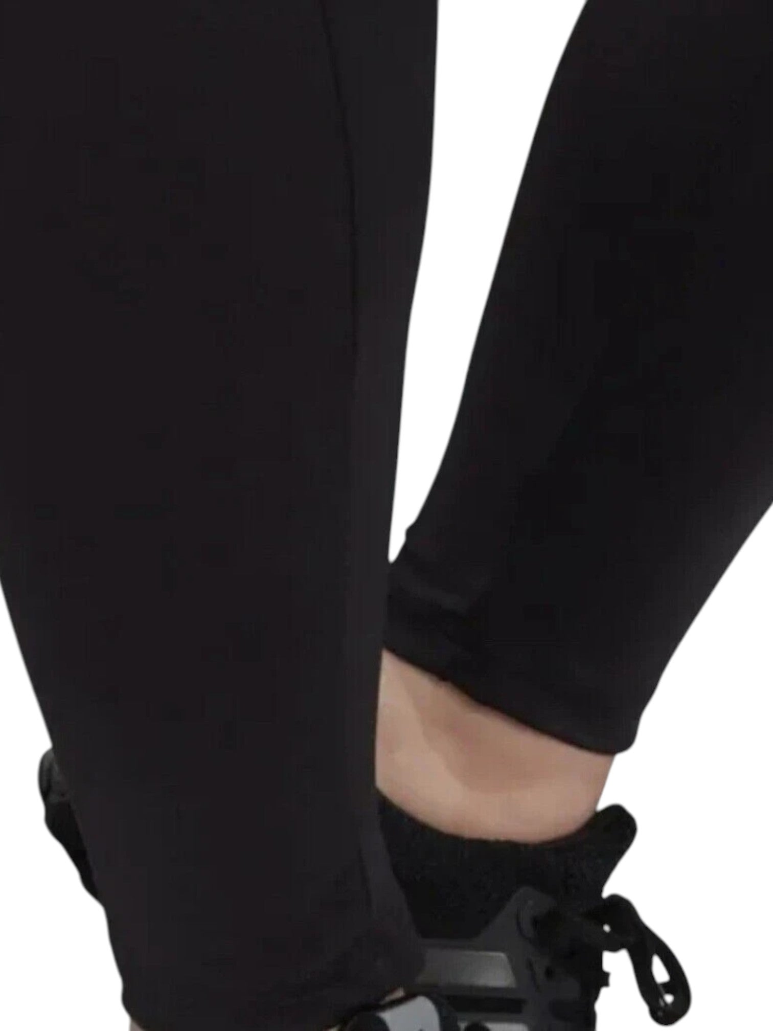 Close-up of a person wearing black pants and shoes on a white background. Adidas, Monza Outlet, Monza Fashion, Shein Outlet