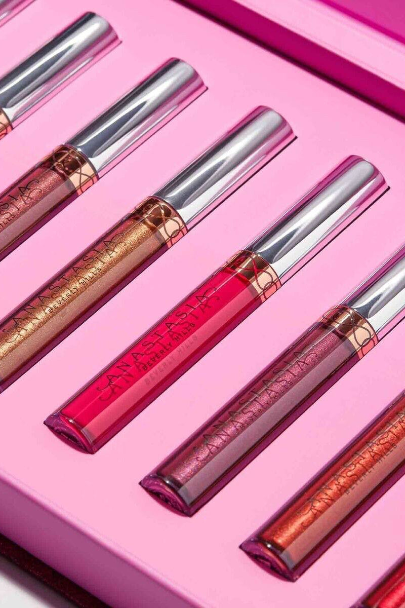 Set of lip glosses with metallic and glossy finishes on a pink background Monza fashion outlet, monza outlet, shein outlet, shien outlet cosmetics, makeup, perfume