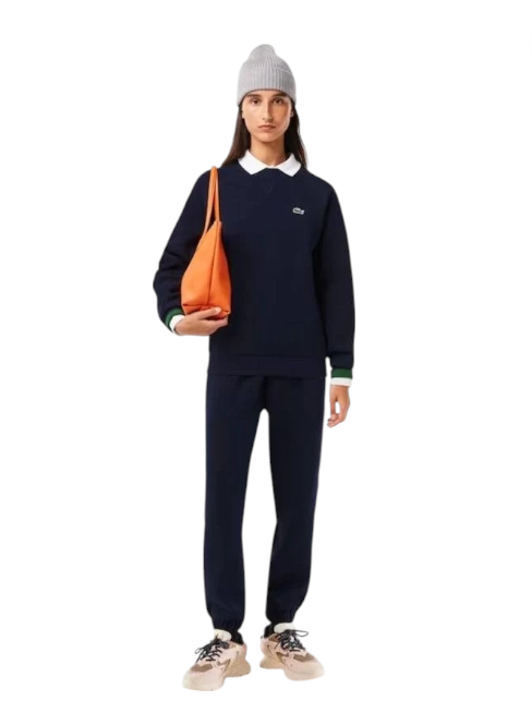 Person wearing a navy blue outfit with an orange bag on a white background Lacoste Monza Outlet Monza Italy