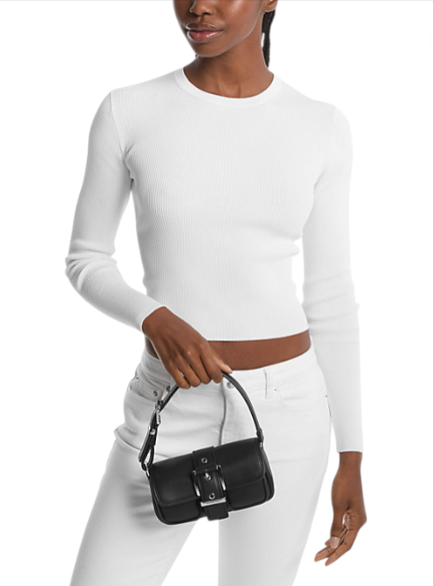 Person wearing a white long-sleeve top and white pants, holding a black handbag on a white background monza outlet, Shein outlet, monza fashion