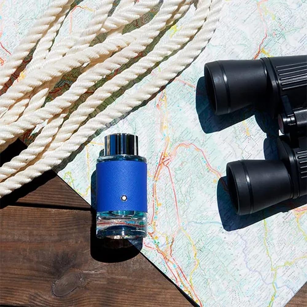 Blue bottle with silver cap on a wooden surface next to binoculars and rope Explorer Ultra Blue Montblanc Monza Outlet