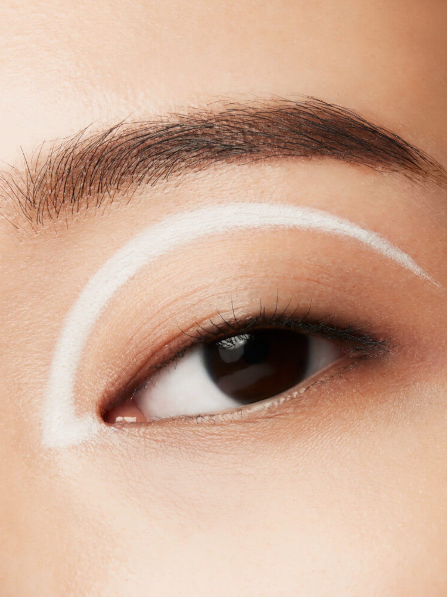 Close-up of an eye with white eyeliner on a neutral background. Shiseido, Monza Outlet, Monza Fashion, Shein Outlet