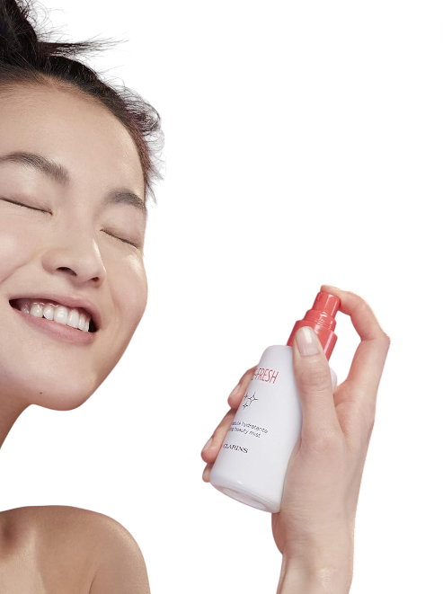 Person holding a skincare product with a plain background. Clarins, Monza Outlet, Monza Fashion, Shein Outlet