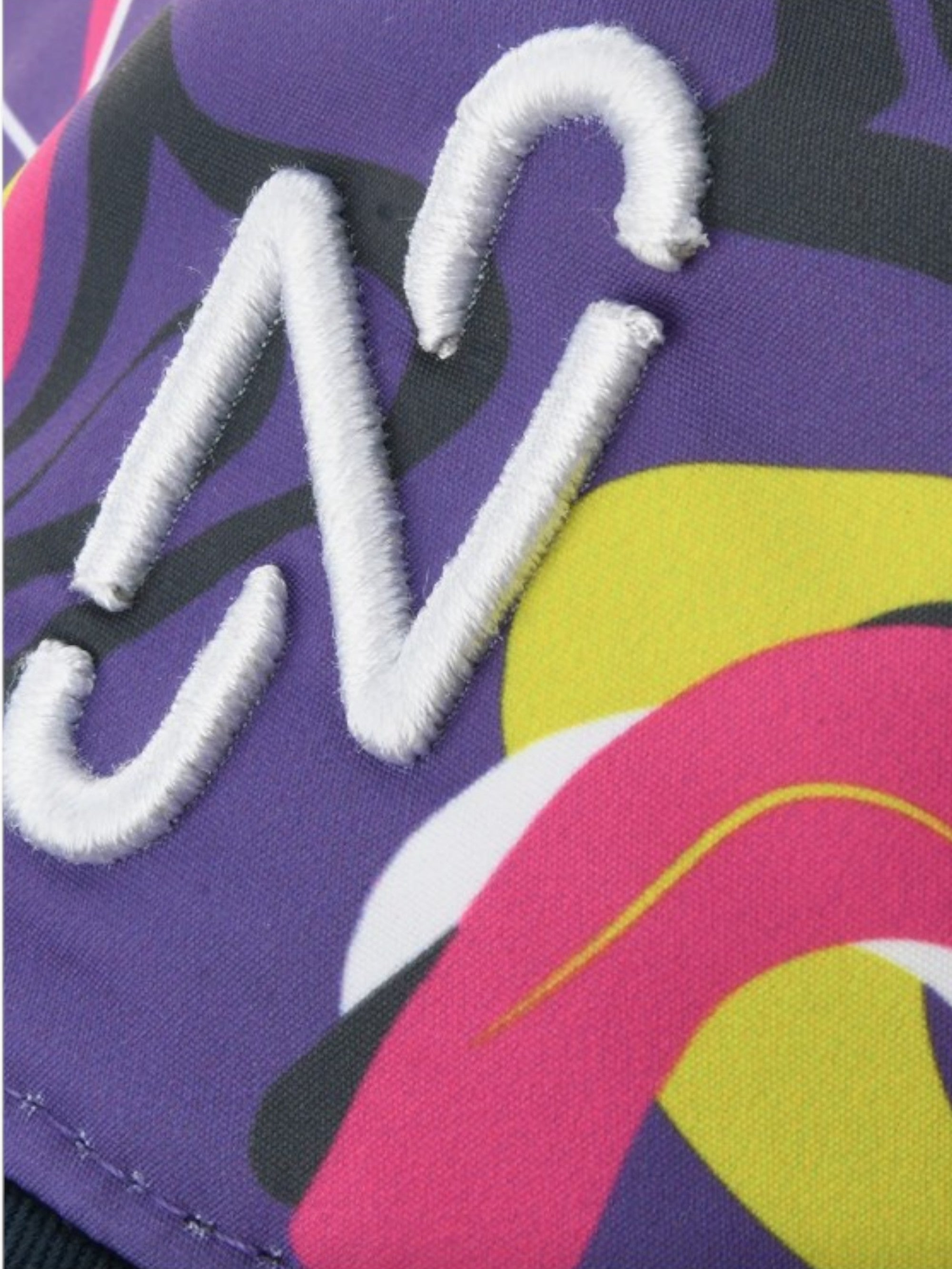 Colorful fabric with a white embroidered letter 'W' on a purple background