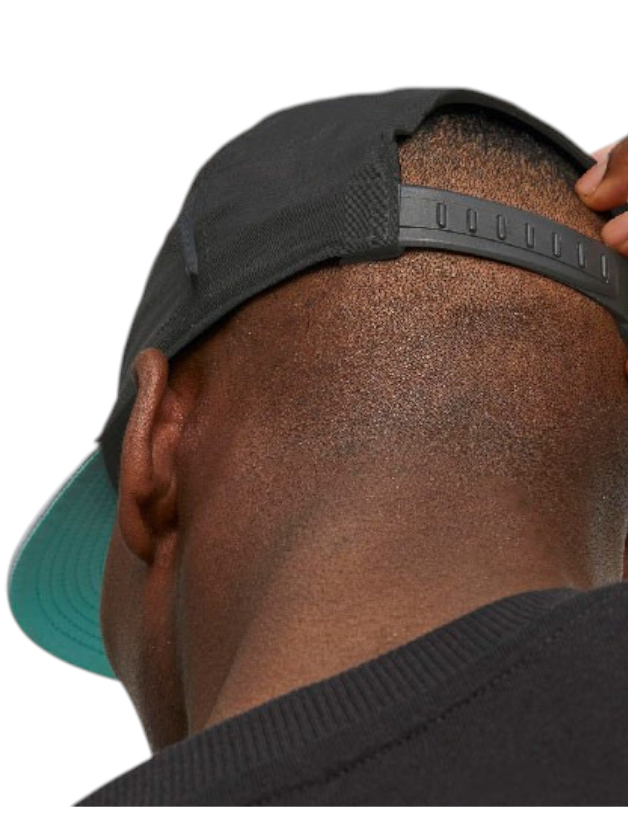 Person wearing a black cap with a green brim, adjusting it on their head. monza outlet, Shein outlet, monza fashion