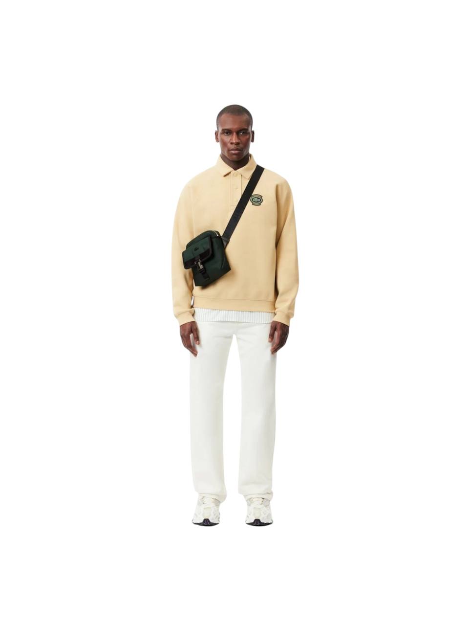 Man wearing a beige jacket and white pants with a green bag on a white background Lacoste Monza Outlet, Monza Fashion, Shein Outlet
