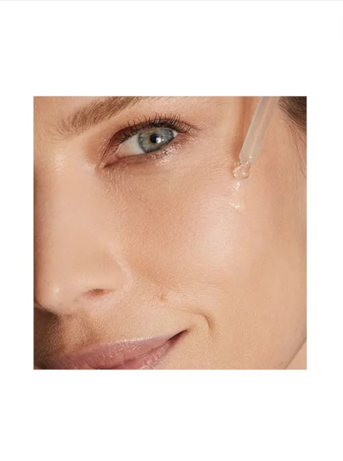 Close-up of a woman's eye with a dropper applying a substance to her skin. Kiko Milano Monza Outlet, Monza Fashion, Shein Outlet