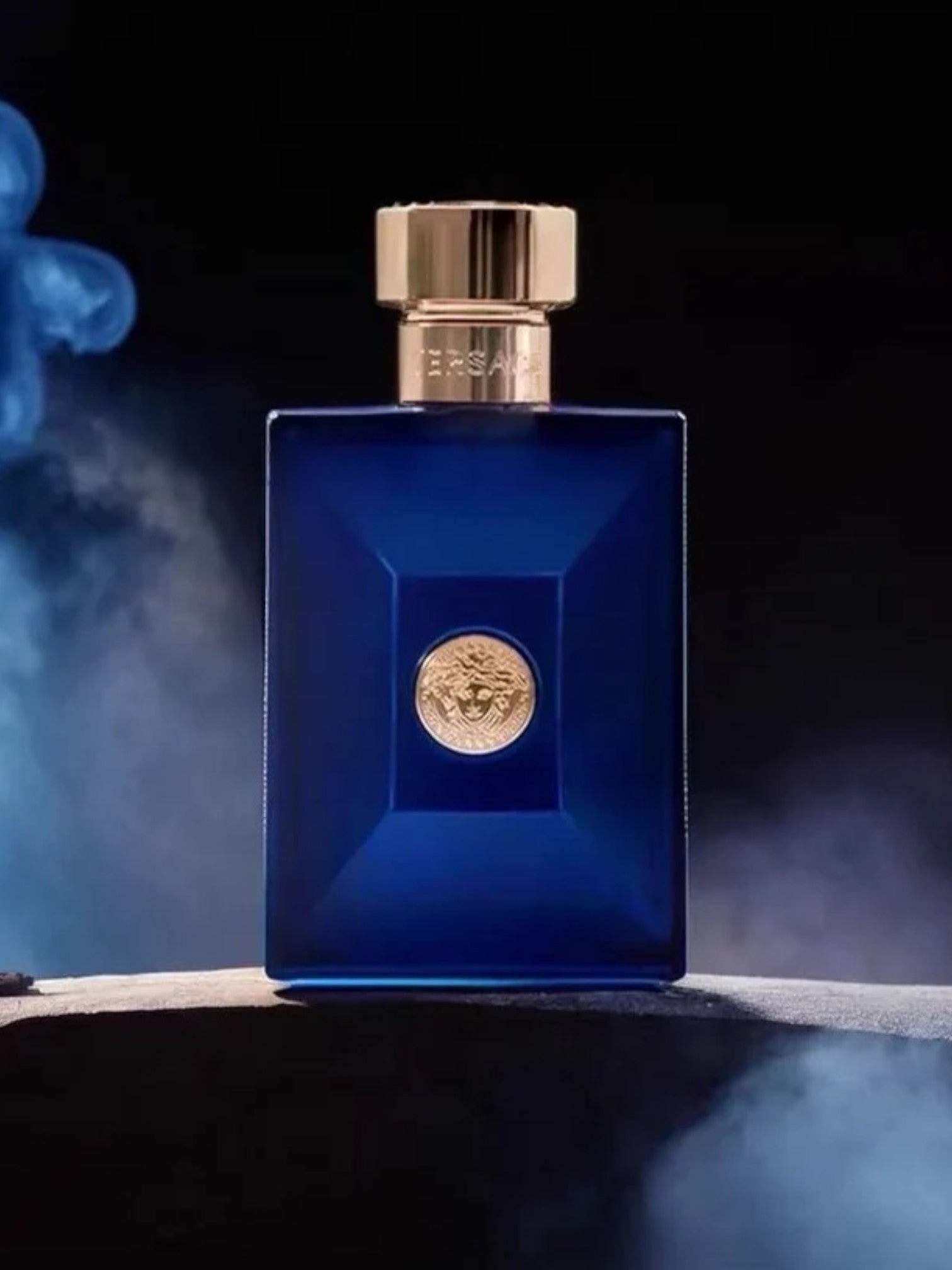 Blue perfume bottle with gold cap on a dark background. Versace, Monza Outlet, Monza Fashion, Shein Outlet