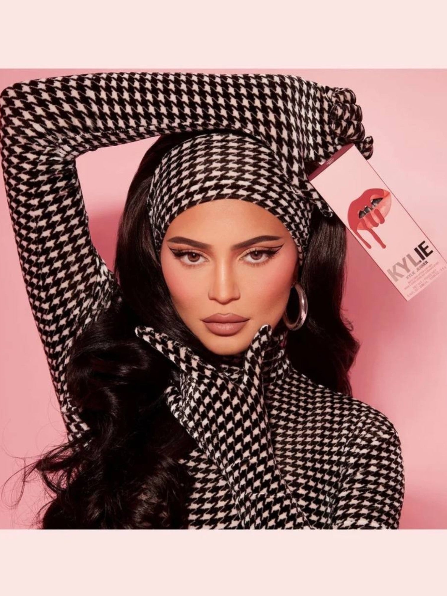 Person wearing a black and white patterned outfit with a pink background, featuring a visible brand logo. Kylie Cosmetics, Monza Outlet, Monza Fashion, Shein Outlet