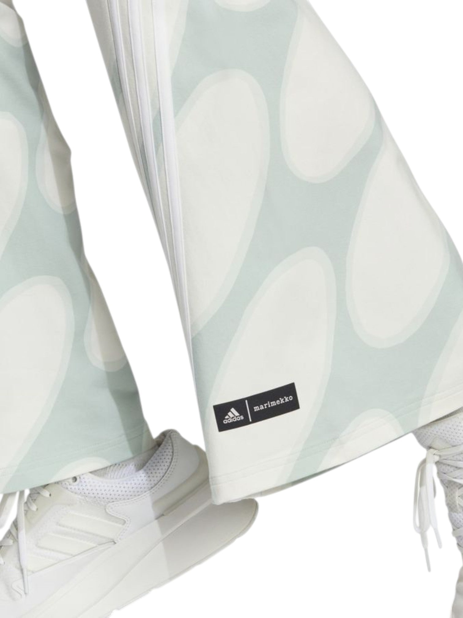 Light blue patterned pants with a visible Adidas label worn by a person, paired with white sneakers. Adidas, Monza Outlet, Monza Fashion, Shein Outlet