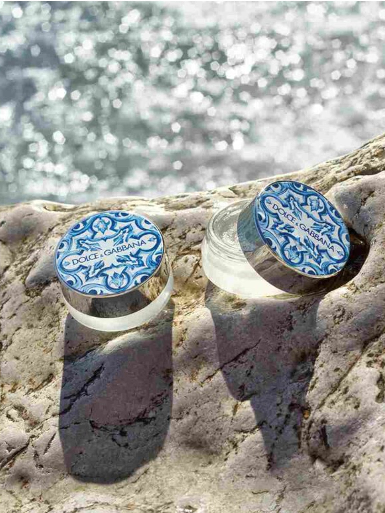 Two Dolce & Gabbana earrings on a rock with water in the background Dolce Gabbana Monza Outlet