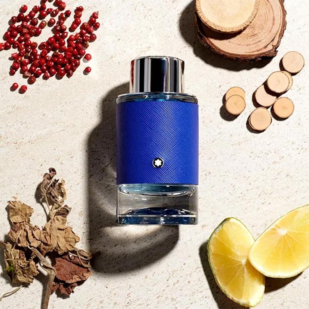 Blue perfume bottle with red berries, lemon slices, and wooden elements on a textured surface Explorer Ultra Blue Montblanc Monza Outlet