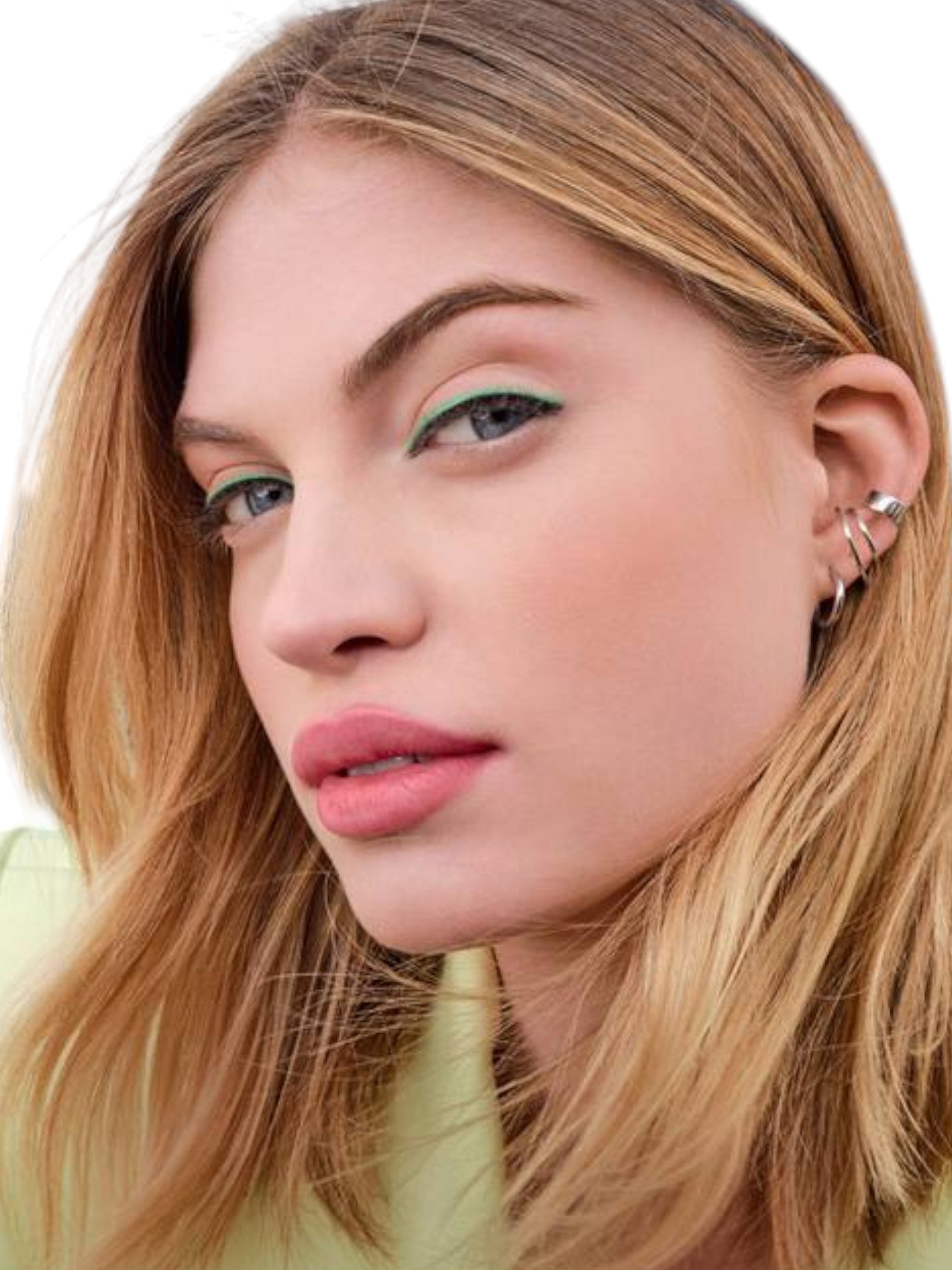 Close-up of a person with blonde hair and green eyeshadow, wearing earrings Maybelline Monza Outlet