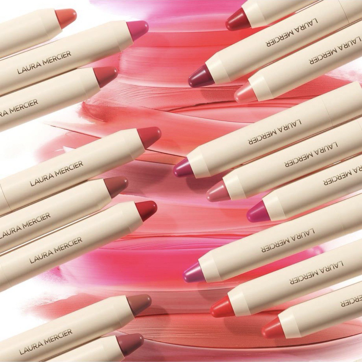 Multiple Laura Mercier lip pencils on a pink background Laura Mercier Monza Outlet