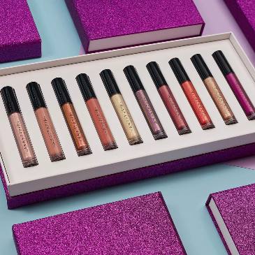 Set of lip glosses in a box with purple packaging on a light blue background Monza fashion outlet, monza outlet, shein outlet, shien outlet cosmetics, makeup, perfume